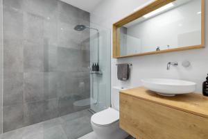 a bathroom with a toilet and a sink and a shower at Little cove gem - walking distance to the most famous Noosa beach! in Noosa Heads