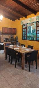 a large wooden table with chairs in a kitchen at "Casa Verde" en Baños de Agua Santa con vista al volcán Tungurahua in Baños