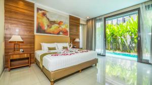 a bedroom with a bed and a large window at Sotis Villas in Canggu