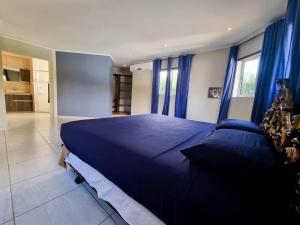 un grande letto blu in una stanza con tende blu di Villa With Pool and Sea View a Fontein Altre 9 foto