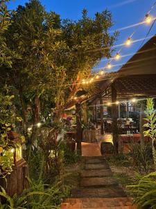 patio z oświetleniem w ogrodzie w nocy w obiekcie นพรัตน์การ์เด้นฮิลล์ w mieście Uthai Thani