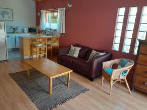 a living room with a couch and a table at Dorset Cottage in Cape Town