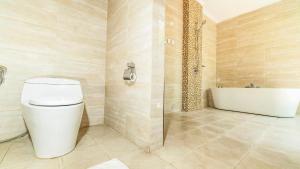 a bathroom with a toilet and a bath tub at Sotis Villas Canggu in Canggu