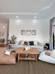 sala de estar con sofá y mesa en 373 pool villa en Chiang Rai
