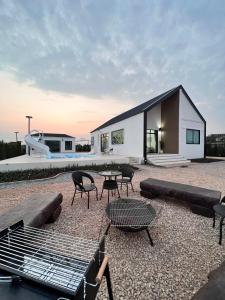 ein kleines Haus mit einem Tisch und Stühlen sowie einer Terrasse in der Unterkunft 373 pool villa in Chiang Rai