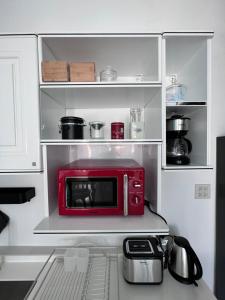 a red microwave sitting on a shelf in a kitchen at 373 pool villa in Chiang Rai