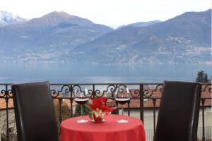 a table with two glasses of wine on a balcony at Hotel Adler in Menaggio