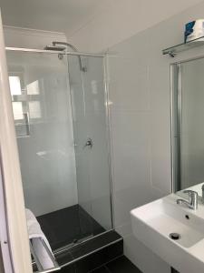 ein Bad mit einer Dusche und einem Waschbecken in der Unterkunft Union Club Hotel in Colac