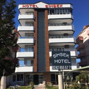 a hotel with a sign in front of it at Hotel Simsek in Finike