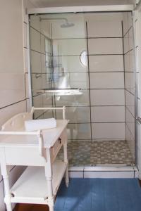 La salle de bains est pourvue d'une douche avec un banc et un lavabo. dans l'établissement Trengwainton House, à Hogsback