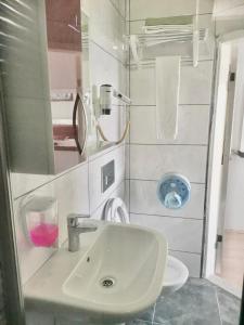 a white bathroom with a sink and a mirror at Hotel Simsek in Finike