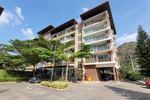 a large building with cars parked in a parking lot at Baan Khaoyai cozy in Ban Tha Maprang