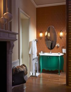 a bathroom with a green sink and a mirror at Aria Hotel Budapest by Library Hotel Collection in Budapest