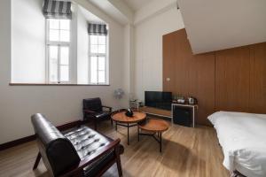 Cette chambre comprend un lit, une table et des chaises. dans l'établissement Anping Kensington Hotel, à Anping
