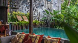 a patio with a swimming pool in a garden at Firefly Eco Lodge in Ubud