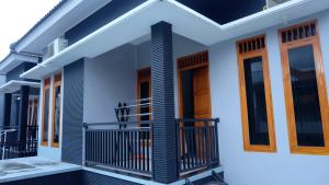 a house with a balcony in front of it at Homestay Jogja Gejayan Dekat Pakuwon Mall by Simply Homy in Yogyakarta
