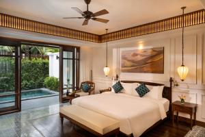 a bedroom with a large bed and a patio at The Anam Mui Ne in Mui Ne