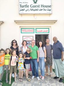 a group of people standing in front of a building at Turtle Guest House in Sur