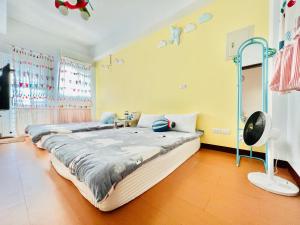 a bedroom with two beds and a fan at Happy Together Guesthouse in Taitung City