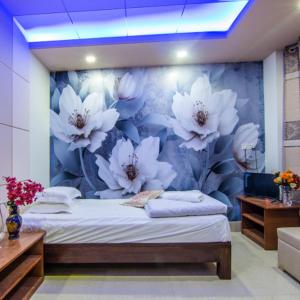 1 dormitorio con un mural de flores en la pared en Hotel Pushpo Bilash en Khulna