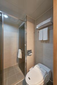 uma casa de banho com um WC e uma cabina de duche em vidro. em Lavi De Atlan Hotel 2 em Busan