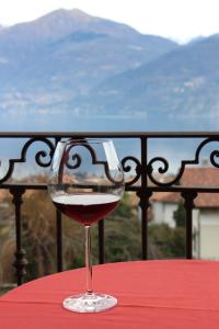 a glass of red wine sitting on a table at Hotel Adler in Menaggio