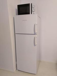 un frigorifero bianco con forno a microonde sopra di Rivitalon pieni päätykaksio - 37 m2 a Jämsä