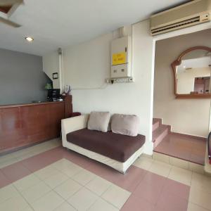 Habitación con sofá, espejo y escaleras. en Kota Lodge en Melaka