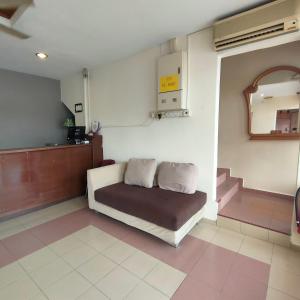 a room with a couch with a mirror and stairs at Kota Lodge in Melaka