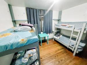 a dorm room with two bunk beds and a wooden floor at Convenient 3-Bedroom Apartment in Baguio