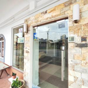 a front door of a store with a stone wall at Kota Lodge in Melaka