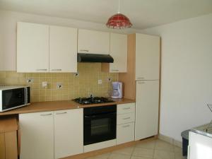 a kitchen with white cabinets and a stove top oven at Gîte Saint-Sauvier, 3 pièces, 6 personnes - FR-1-489-404 