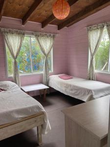 1 dormitorio con 2 camas y ventana en Soleada, en Punta del Diablo
