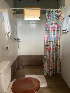 y baño con aseo y cortina de ducha. en Soleada, en Punta del Diablo