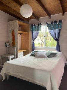 Un dormitorio con una cama grande y una ventana en Soleada, en Punta del Diablo