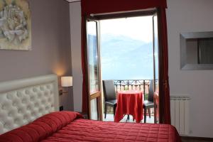 a bedroom with a bed and a table and a balcony at Hotel Adler in Menaggio