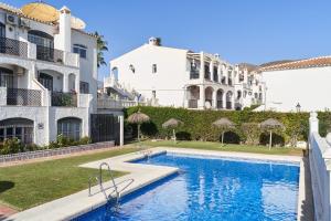 a swimming pool in front of a building at Verano Azul in Nerja