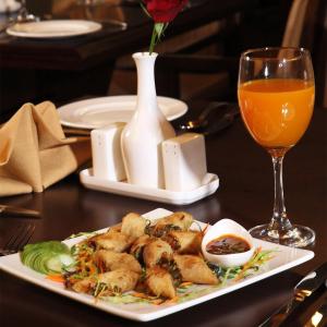 a plate of food on a table with a glass of orange juice at Gobindgarh Jaisalmer in Jaisalmer