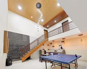 a ping pong table in a room with a staircase at Pawna Mountain View 4BHK in Āmbavna
