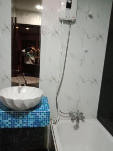 La salle de bains est pourvue d'un lavabo blanc et d'un miroir. dans l'établissement NewYork Suite Hotel, à Ban Ko
