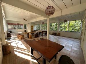a large room with wooden tables and large windows at Golden Sword with Boat in Sai Yok