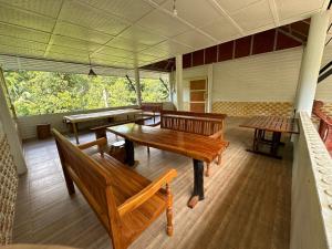 a room with wooden benches and tables in a building at Golden Sword with Boat in Kanchanaburi
