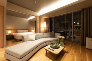 a living room with a couch and a bed at Fenix West in Furano