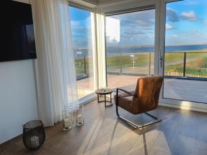 ein Wohnzimmer mit einem Stuhl und einem großen Fenster in der Unterkunft Elegant Holiday Home in Kamperland next to the Lake in Kamperland