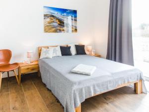 ein Schlafzimmer mit einem Bett, einem Stuhl und einem Fenster in der Unterkunft Elegant Holiday Home in Kamperland next to the Lake in Kamperland