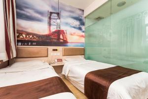 twee bedden in een kamer met een muurschildering van een stadion bij Thank Inn Chain Hotel Shandong Rizhao Zhaoyang Road in Rizhao