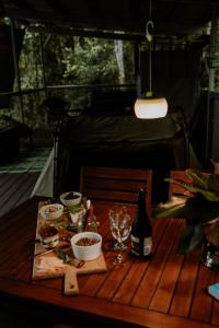 einen Holztisch mit Essen und einer Flasche Wein in der Unterkunft Castle Rock Farm in Byfield