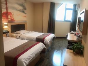 Habitación de hotel con 2 camas y ventana en Thank Inn Chain Hotel henan zhengzhou xinzheng city north china road xuanyuan lake, en Zhengzhou