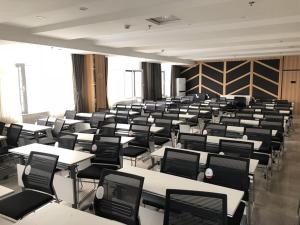 an empty classroom with tables and chairs in it at Thank Inn Plus Hotel Hebei Shijiazhuang Yuhua District of Hebei Normal University in Shijiazhuang
