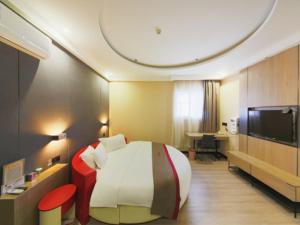 ein Hotelzimmer mit einem großen Bett und einem Schreibtisch in der Unterkunft Thank Inn Plus Hotel Hebei Shijiazhuang Yuhua District of Hebei Normal University in Shijiazhuang